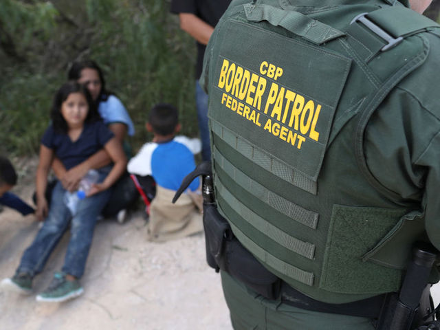 Inside Border Protection's processing detention center: Chain link fences and thermal blankets