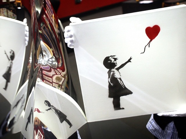 Banksy painting 'self-destructs' moments after being sold for $1.4 million at auction